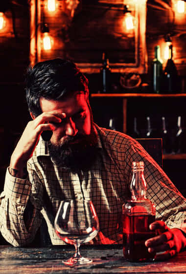 Мужчина пьет алкоголь в баре