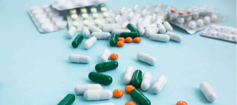 Разноцветные таблетки на голубом столе