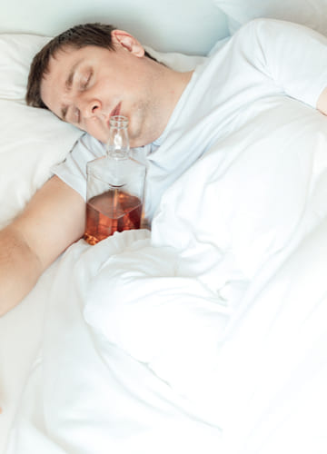 Мужчина спит с открытой бутылкой около рта