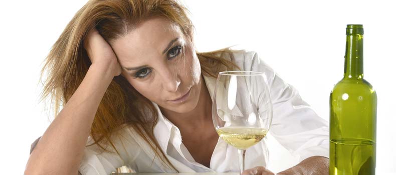 грустная женщина с бокалом вина смотрит в камеру