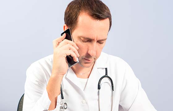 мужчина врач говорит по телефону
